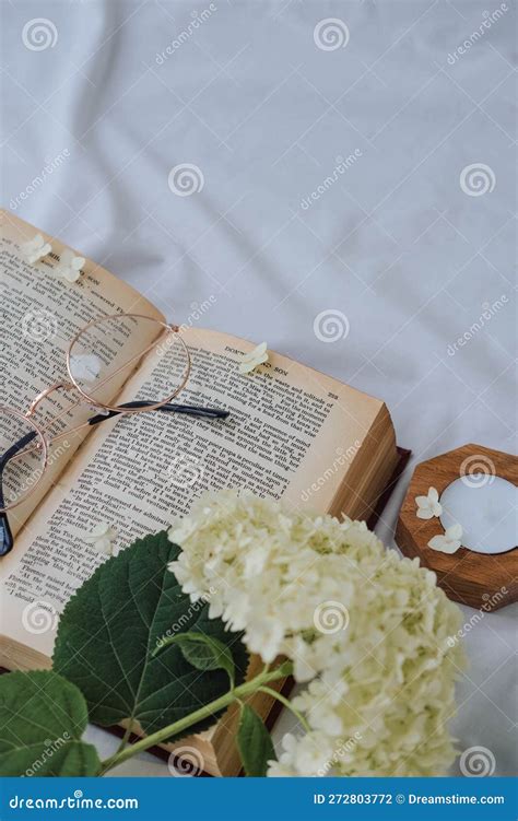 Libro Abierto Con Flores De Hidrangea Y Gafas En Cama Blanca Foto de ...