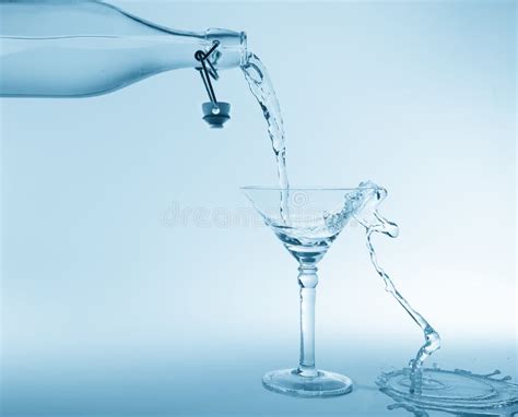 Clear Water Pour Out of Bottle Splash into Glass and Spill with Stock ...