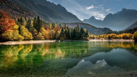 Calm Body Of Water Surrounded With Trees And Mountains During Daytime ...