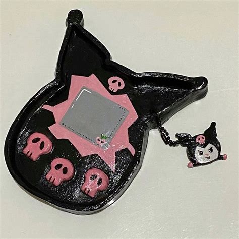 a black and pink purse with skulls on the bottom, an animal keychain ...