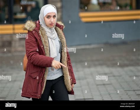 A muslim girl wearing a pashmina and a winter coat. Taksim Square ...