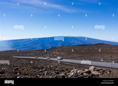 Cars on Mauna Kea summit road. Mauna Loa in background. Big Island of ...