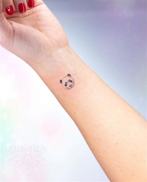 Fine line panda tattoo on the wrist.