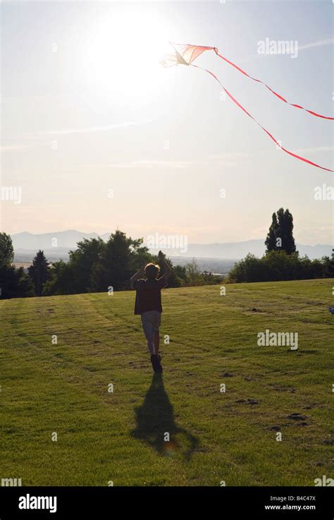 young boy flying kite into the sunset Stock Photo - Alamy