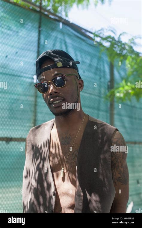 Young man wearing a baseball cap and sunglasses Stock Photo - Alamy