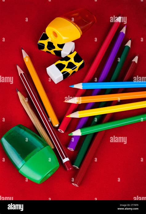 Colored pencils, erasers, sharpeners isolated on red background Stock ...