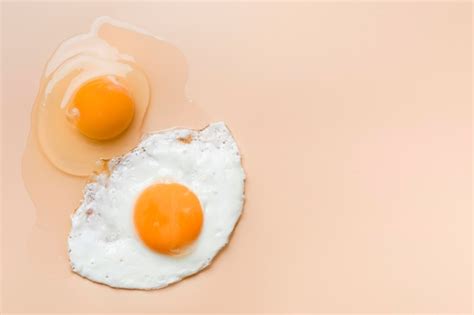 Fried egg and raw egg yolk with copy-space | Free Photo