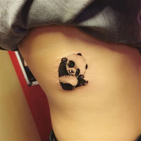 Illustrative panda tattoo on the right side ribcage.