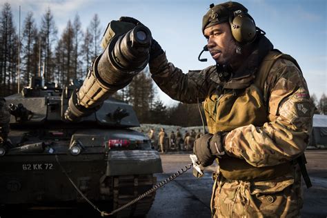 A tank crewman checking his Challenger is ready for the range ...