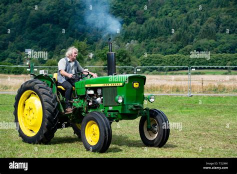 Man driving vintage John Deere Tractor, UK Stock Photo - Alamy