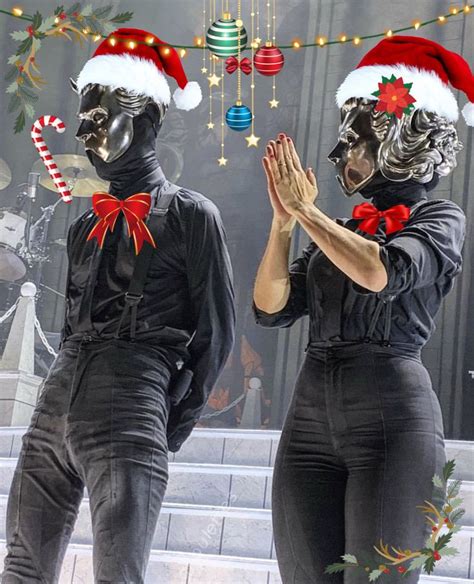 two people dressed in black with christmas decorations on their heads ...