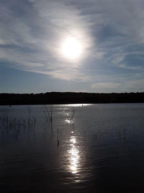 Boat crossing sunset reflection. Bull Creek Peninsula, Skiatook Lake ...