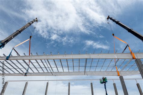 Construction worker working at boom lift installation steel roof beam ...