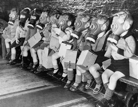 Toddlers on bench in gas masks during WWII ~ vintage everyday