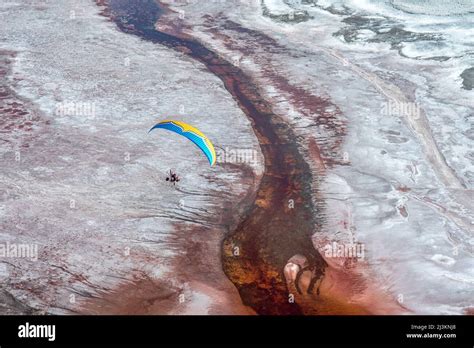 A paramotor pilot flies over Owens Lake, a mostly dry lake bed, in the ...