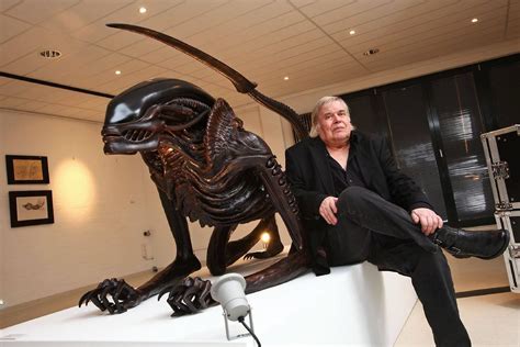 The master alongside a life-sized statue of his unused design for Alien 3.