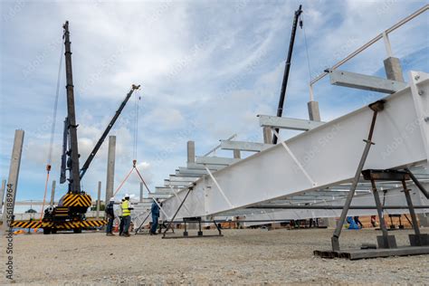 Construction worker working at boom lift installation steel roof beam ...