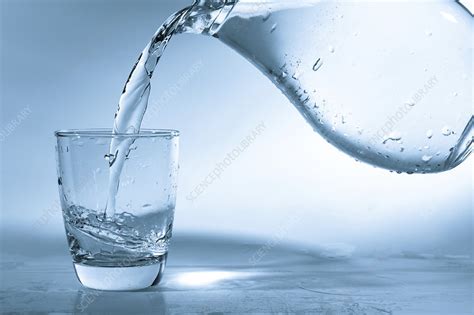 Pouring water into glass from a jug - Stock Image - F021/3874 - Science ...