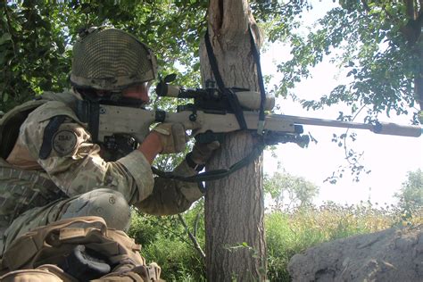 A British Army sniper steadies his L115A3 rifle, with the help of a ...