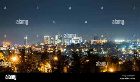 A panoramic view of Kigali city skyline lit up at night, under a deep ...