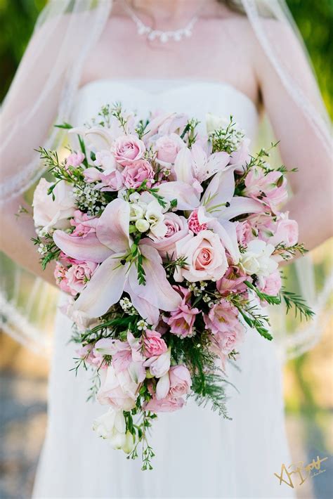 a bride holding a bouquet of pink and white flowers