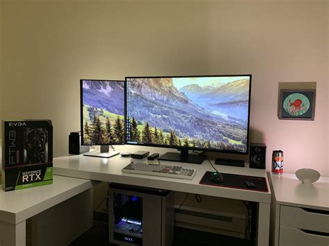 two computer monitors sitting on top of a white desk next to a keyboard ...