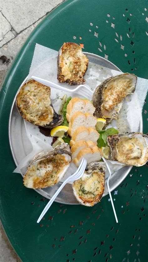 oysters are served on a plate with lemon wedges and parmesan cheese