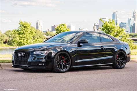 a black car parked in front of a city skyline