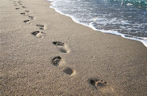 Premium Photo | Footprints in the sand near the sea waves