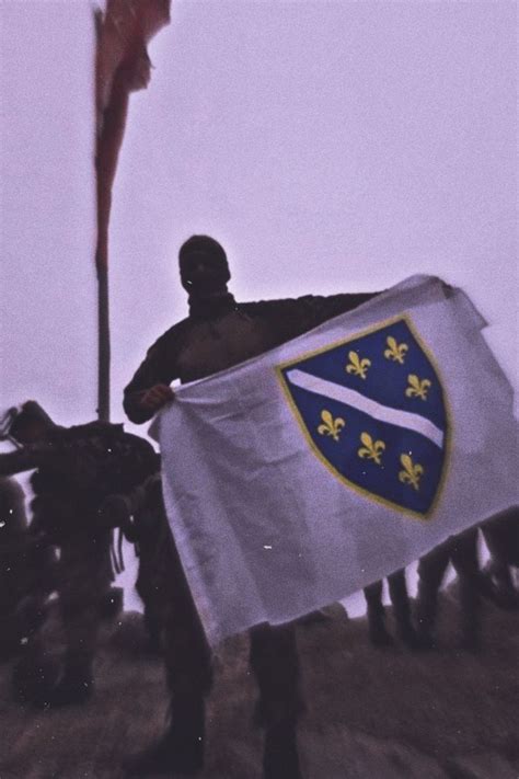 a group of people holding flags on top of a hill