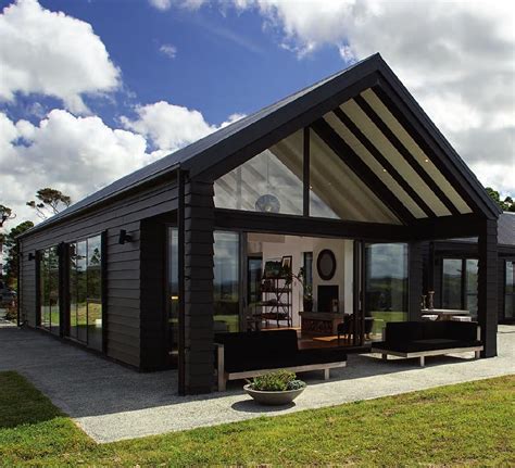 a small black house with glass walls on the front and side windows ...