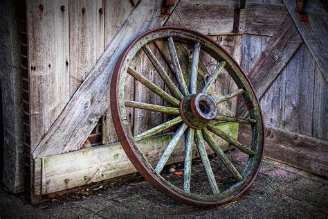 Old Rustic Wooden Wagon Wheel leaning against an old Barn Door ...