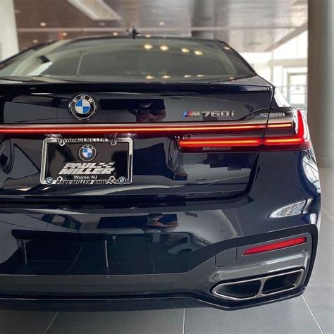 the rear end of a black bmw car in a showroom with its license plate