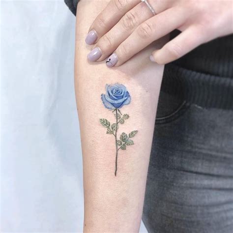 Blue rose tattoo on the inner forearm.