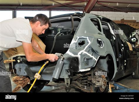 Car mechanic at work in body shop Stock Photo - Alamy