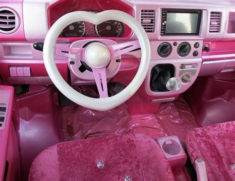 the interior of a pink and white car