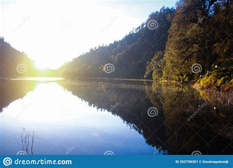 Reflection of Trees in Clear Water at Sunrise on Ranu Kumbolo Lake ...