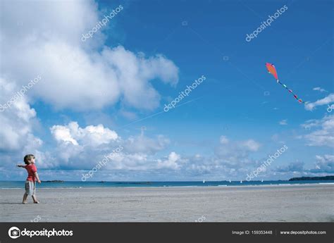 Boy with flying kite standing at beach Stock Photo by ©ImageSource ...