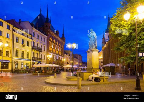 Torun Town Hall and monument of Copernicus at night Stock Photo - Alamy