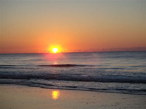 the sun is setting over the ocean with waves