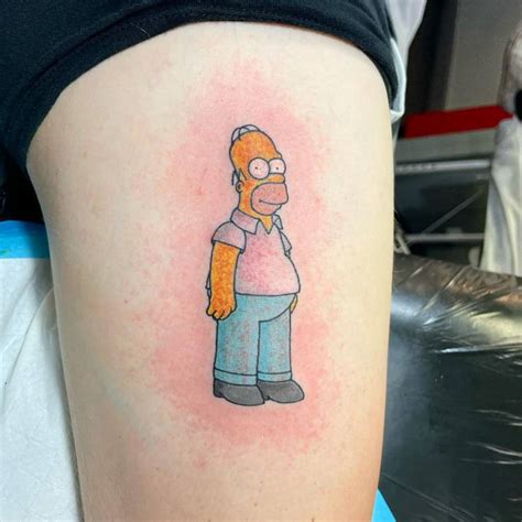 Homer Simpson tattoo located on the thigh.