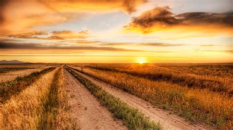 Download A sunset view of a dirt road in the countryside. Wallpaper ...