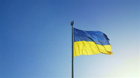 The Ukrainian flag of blue and yellow national colors on the flagpole ...