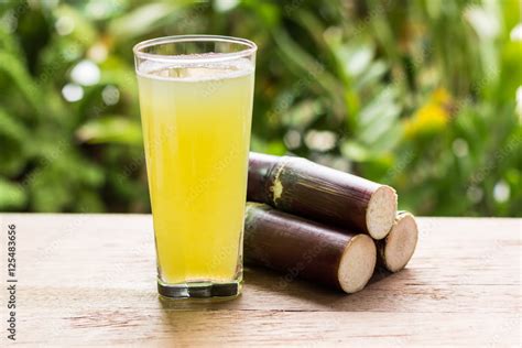 Sugarcane juice with piece of sugarcane on wooden background Stock ...