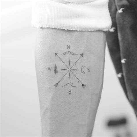 Traveler's crossed arrows tattoo on the inner forearm.