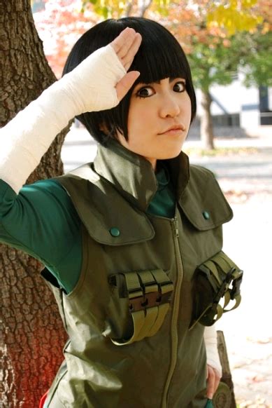 a woman dressed in an anime cosplay standing next to a tree with her ...