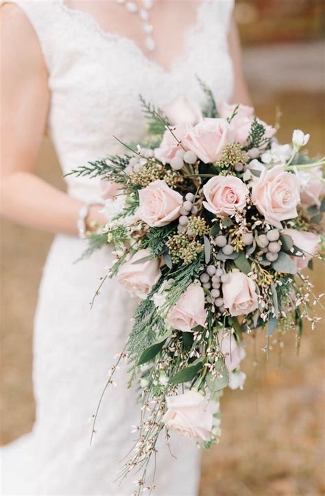 a woman in a wedding dress holding a bridal bouquet with pink roses and ...