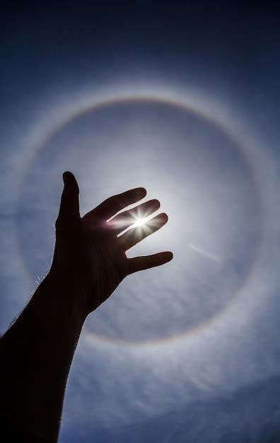 Premium Photo | Hand silhouette with circular sun halo