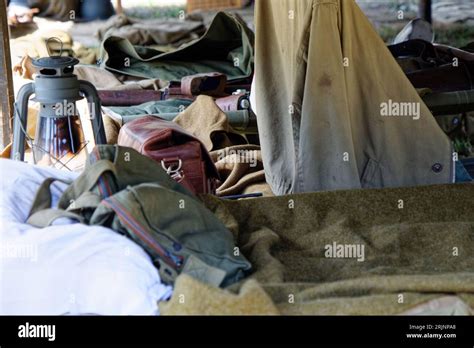 A camouflaged military tent set up in the outdoors, with army-green ...