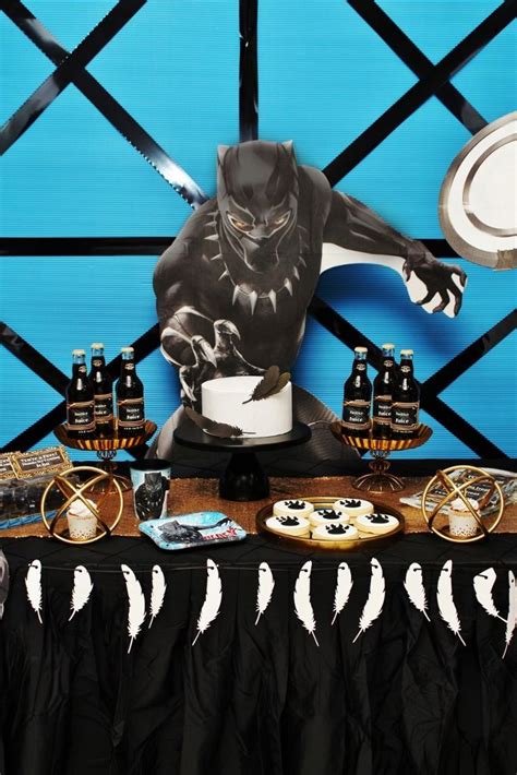 a table topped with cakes and cupcakes covered in frosting next to a statue